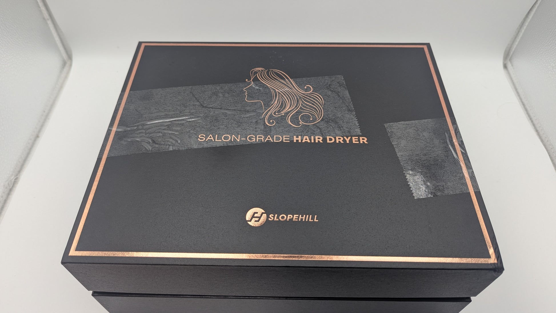 Slopehill Ionic Hair Dryer elegant packaging in black, highlighting salon-grade quality and featuring a delicate hair illustration.